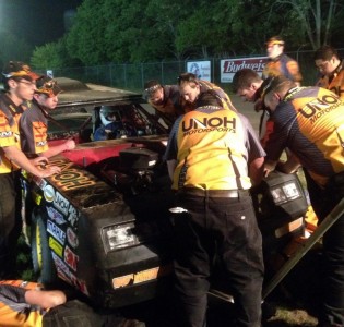 Members of the UNOH Motorsports team work on the No. 2 stock car moments before the feature race Friday at Limaland