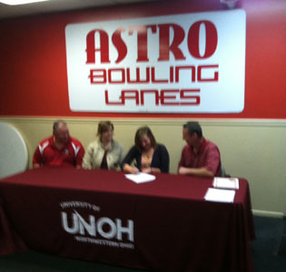 Casey Feltz signs her letter of intent with her parents and UNOH coach Todd Book looking on